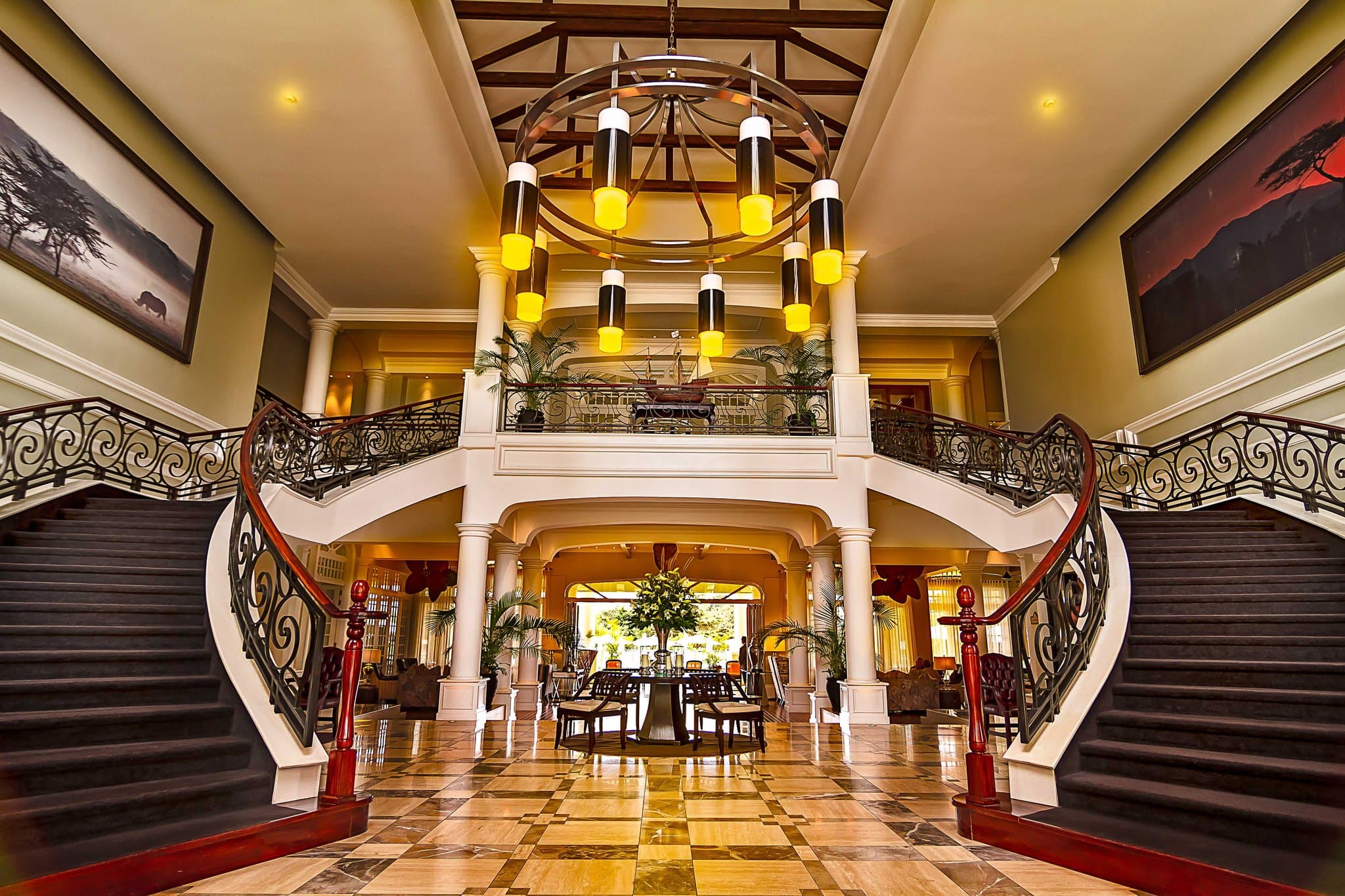 Grand plantation-style hotel exterior of Hemingways Nairobi with manicured lawns and view of Ngong Hills in distance