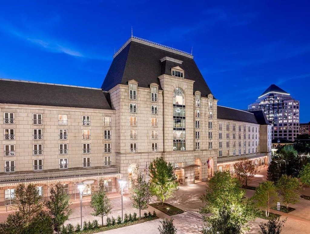Hotel Crescent Court 的石灰岩庭院，拥有法式文艺复兴风格的拱门和中央喷泉。