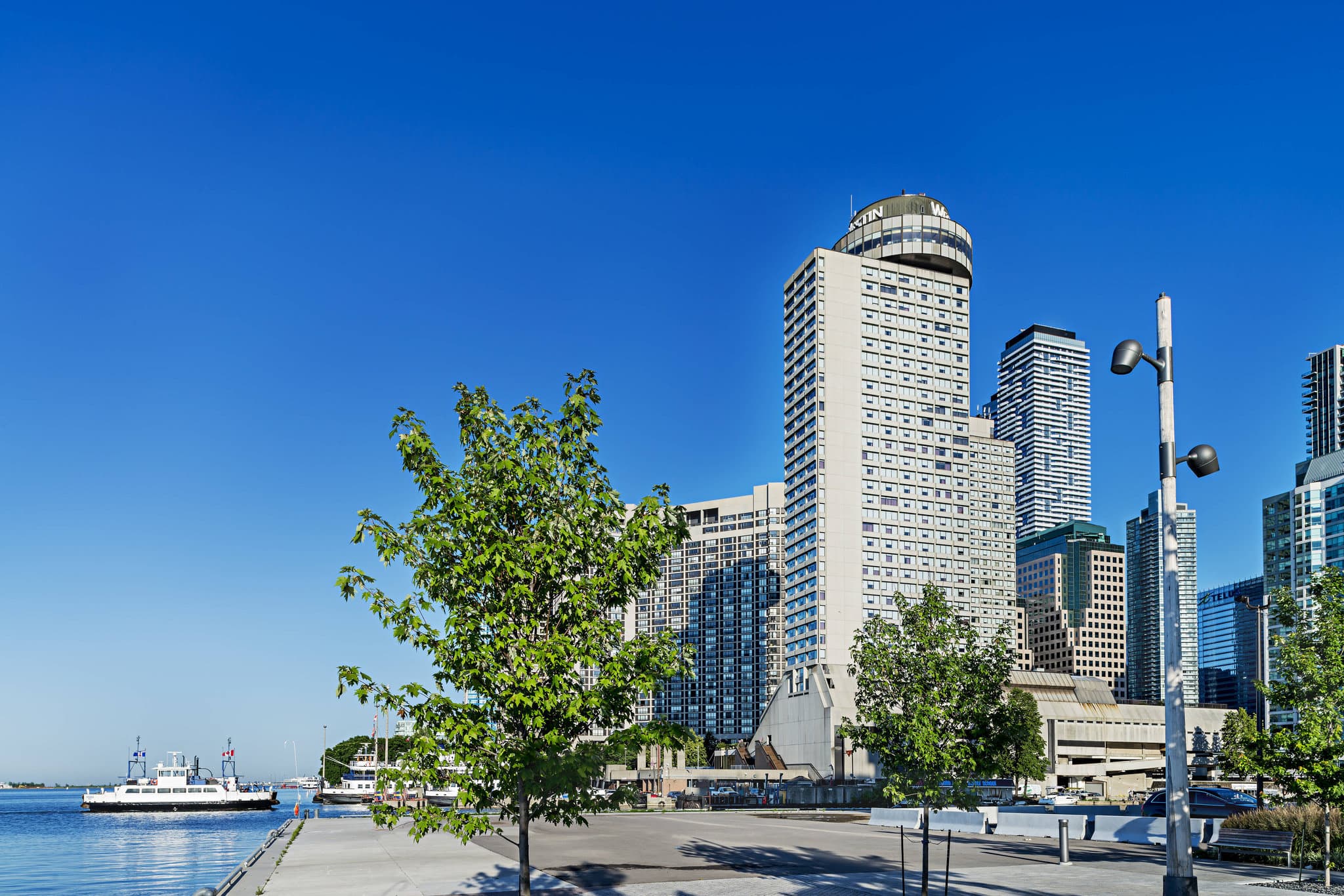 A panoramic view of the Toronto skyline seen from a high-floor suite at The Westin Harbour Castle, featuring the CN Tower and Lake Ontario.