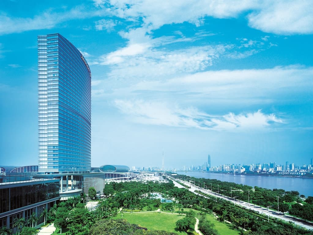 A sprawling 1,000sqm outdoor lagoon pool at Shangri-La Guangzhou surrounded by lush tropical gardens and palm trees.