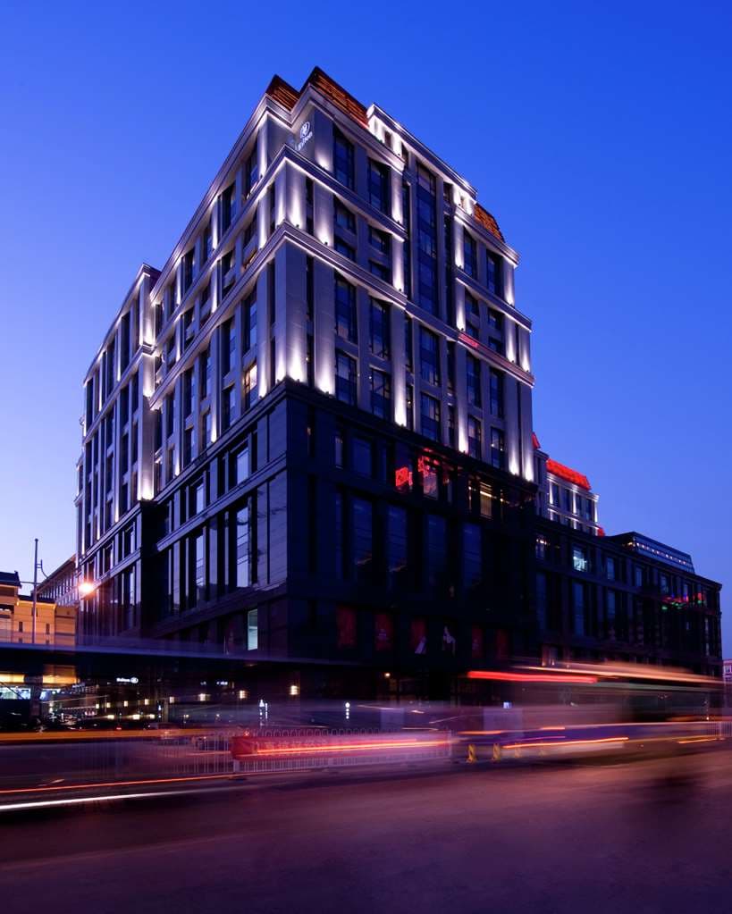 北京王府井希爾頓酒店頂層室內泳池，玻璃天幕採光，光影效果極具戲劇感。