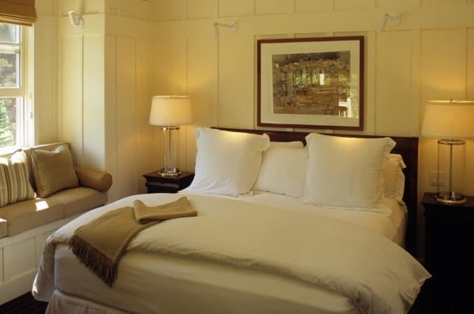 A secluded lodge suite at Meadowood Napa Valley featuring a private terrace with a fire pit surrounded by dense forest.