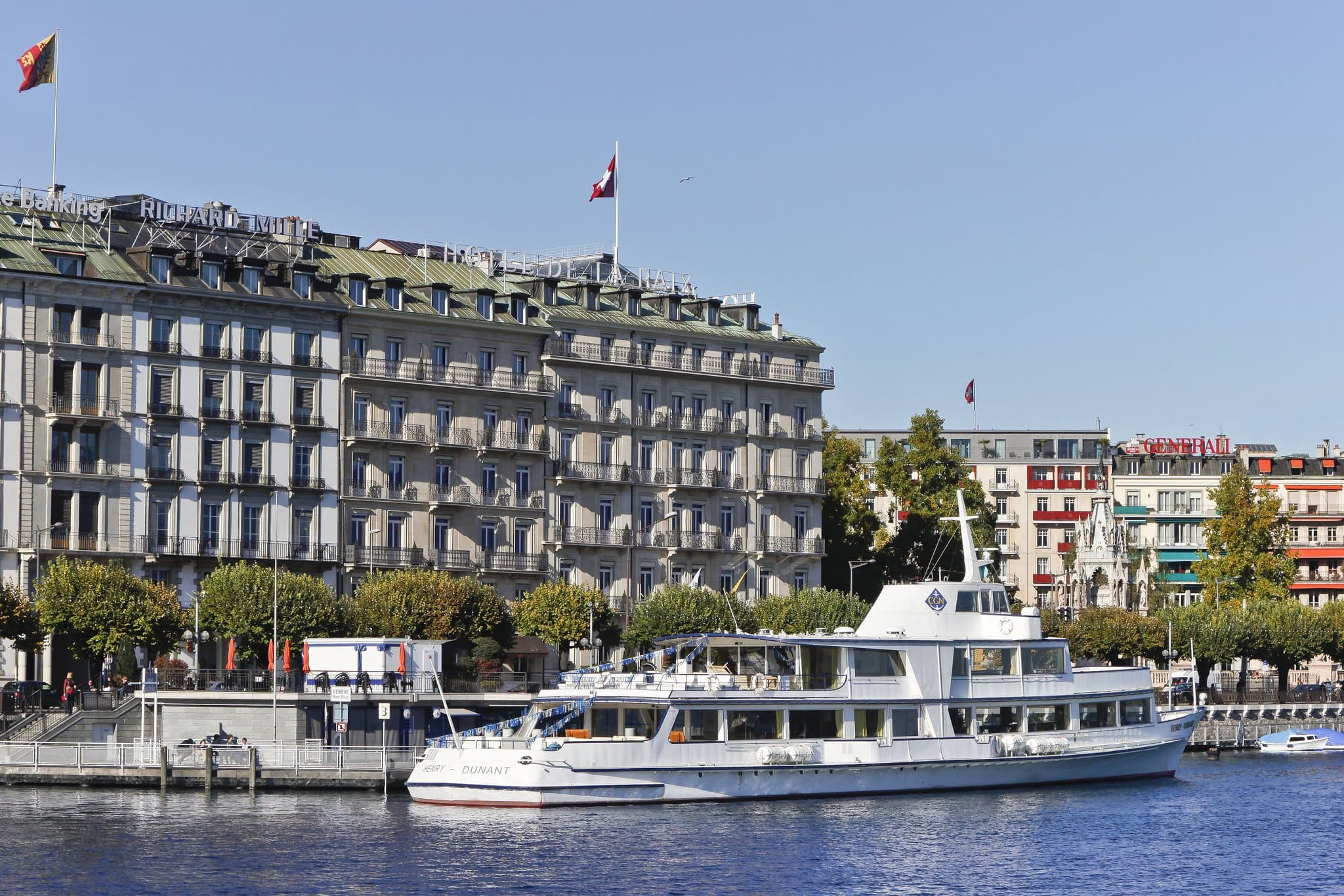 A moody, sophisticated shot of the Fiskebar raw counter with chefs plating Nordic dishes, contrasted against the hotel's historic atrium.