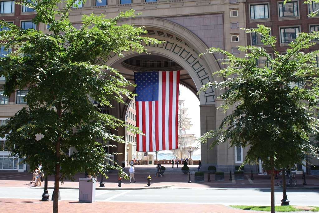 The 60-foot copper-domed arch of the Boston Harbor Hotel framing a view of the marina and docked yachts.