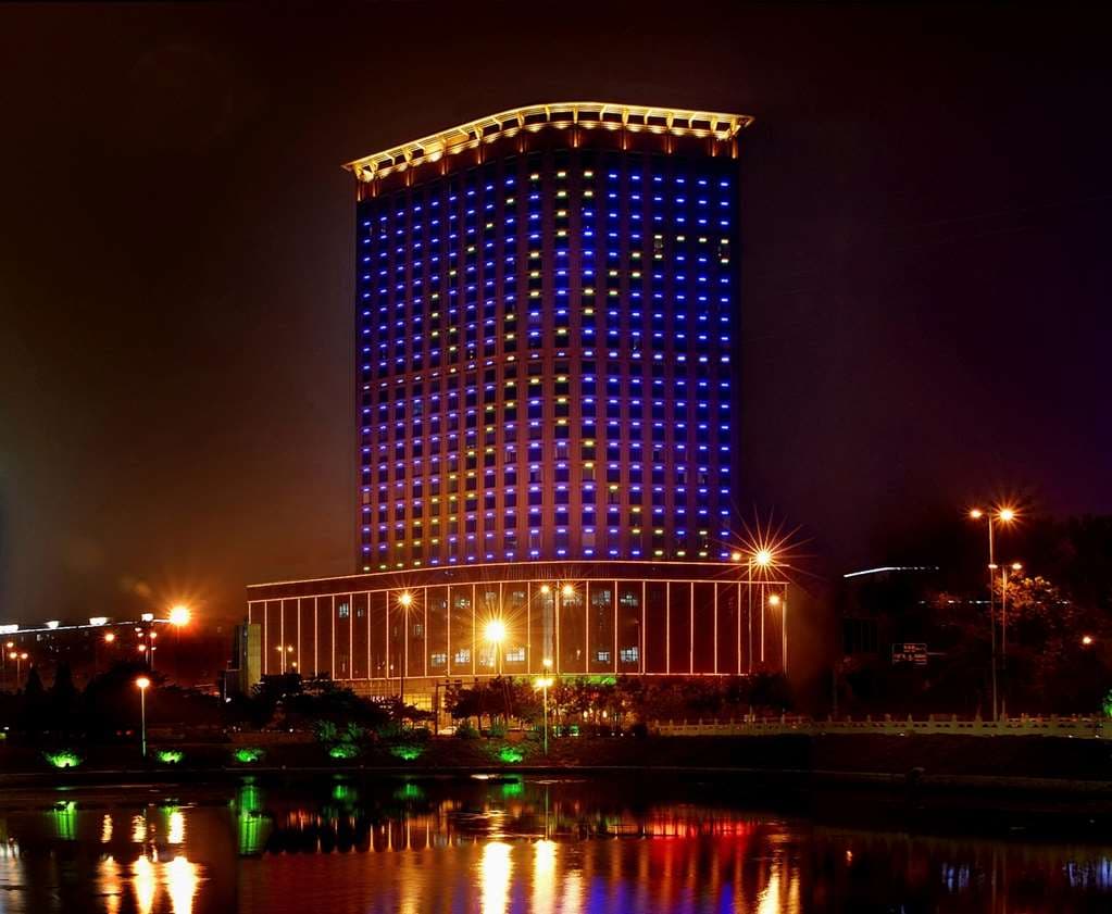Dusk view from a high-floor room at Swissôtel Shenyang, framing the illuminated Liaoning Broadcast and TV Tower against a deep blue skyline.