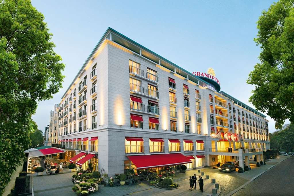 The light-filled, glass-roofed atrium of Grand Elysée Hamburg featuring the Boulevard Café and grand staircase.