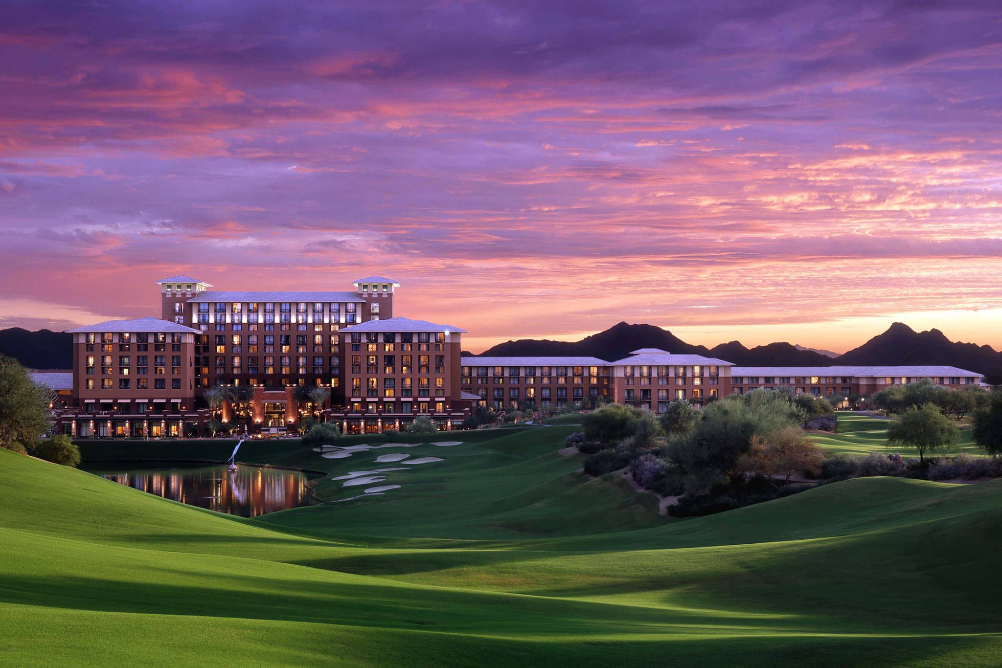 A bagpiper playing on the Westin Kierland golf course at sunset with fire pits in the foreground.