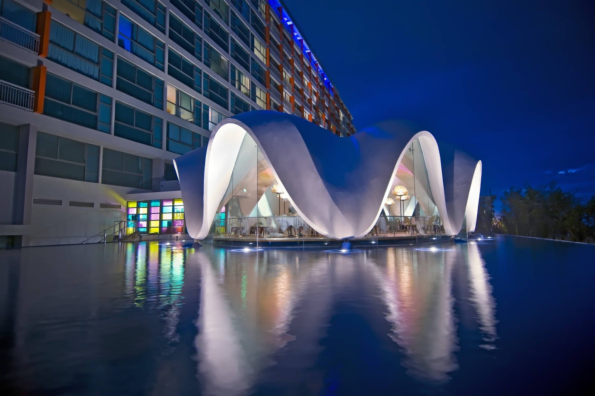 The iconic shell-shaped Perla restaurant floating in La Concha Resort's infinity pool at sunset.
