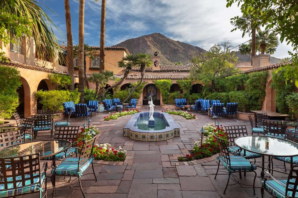 The iconic Palm Alley driveway at Royal Palms Resort with towering palm trees framing a view of Camelback Mountain.