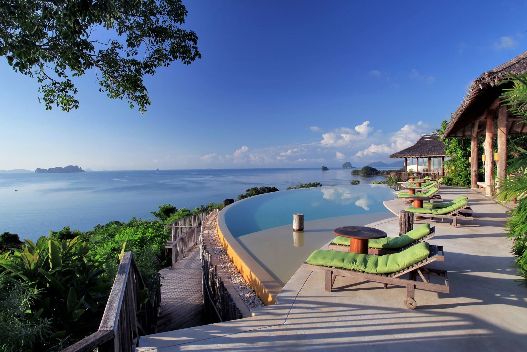 Infinity pool at Six Senses Yao Noi overlooking limestone karsts in Phang Nga Bay at sunset.