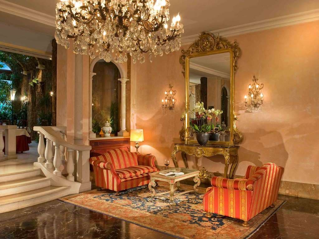 The Winter Garden at Hotel Papadopoli featuring climbing tropical plants and bistro seating designed by Pietro Porcinai.