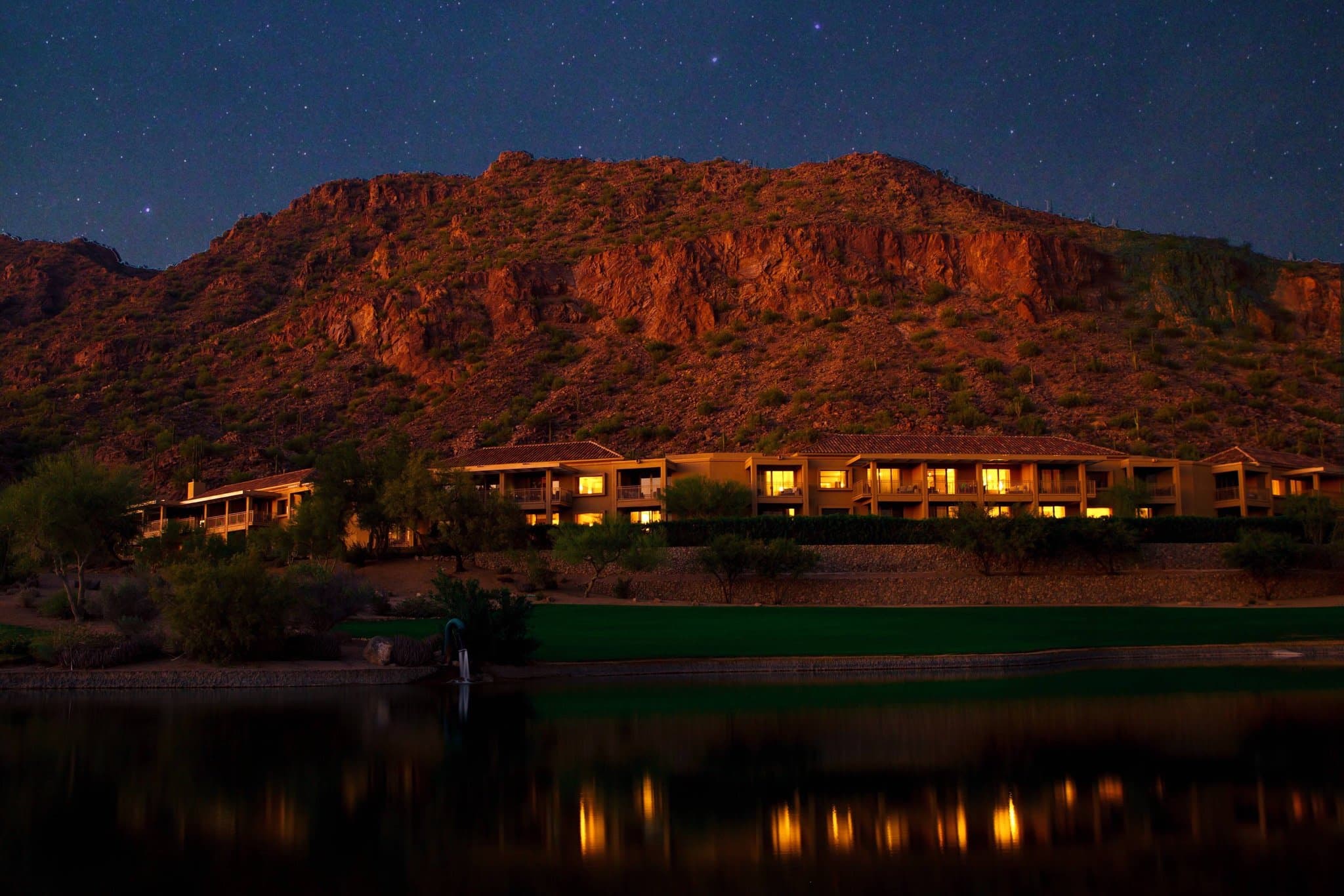 The Mother-of-Pearl pool at The Phoenician reflecting the red rocks of Camelback Mountain under a bright blue sky.