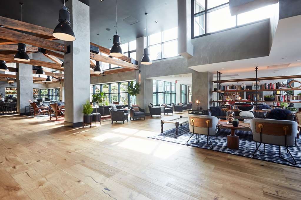 Hotel Kabuki lobby featuring high industrial ceilings, a vintage factory window wall, and loft-style lounge seating.