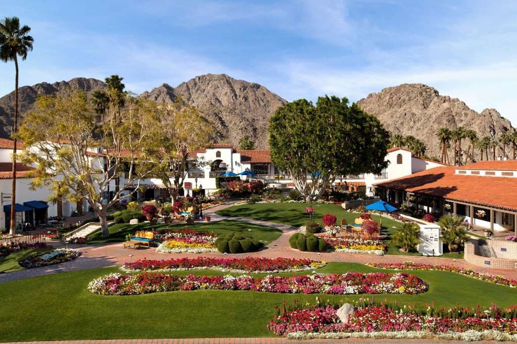 La Quinta 度假村的西班牙殖民風格白色小屋，配有標誌性的寶藍色木門，四周環繞著盛開的九重葛和聖羅莎山脈。
