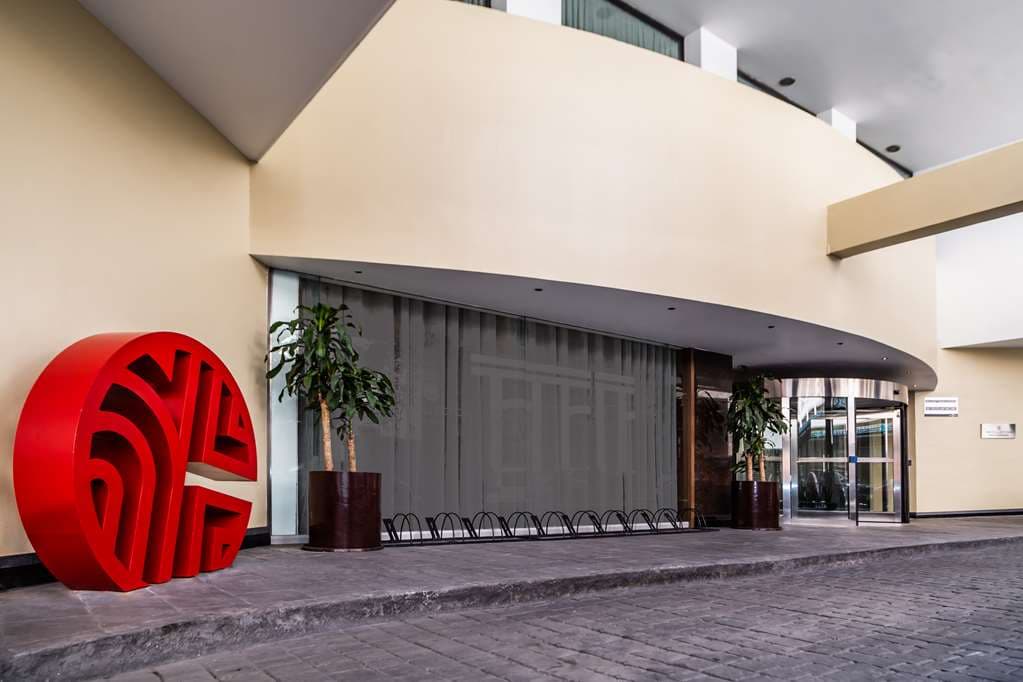 A dramatic low-angle shot of the NH Collection Mexico City geometric lobby staircase with modern lighting contrasts.