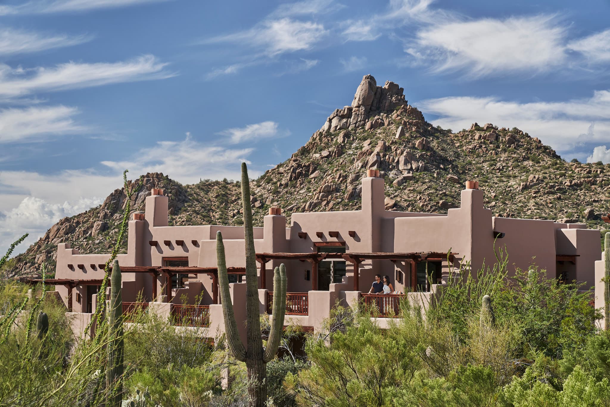 Adobe casitas of Four Seasons Scottsdale blending into the granite boulders of Pinnacle Peak at sunset.