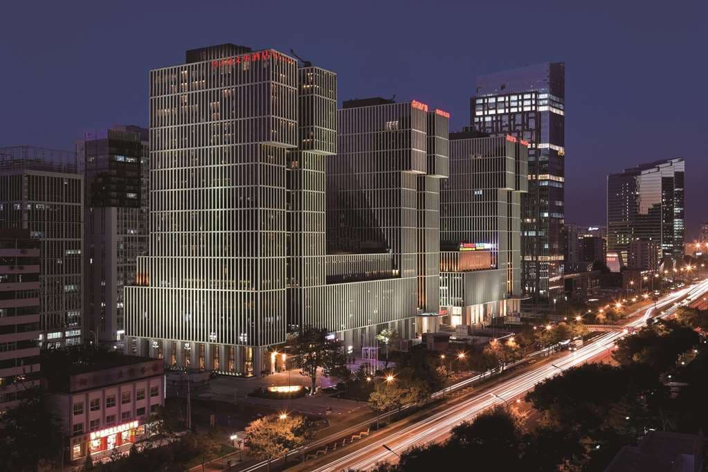 The expansive 28-meter indoor pool at Wanda Vista Beijing featuring floor-to-ceiling windows overlooking the Beijing CBD skyline.
