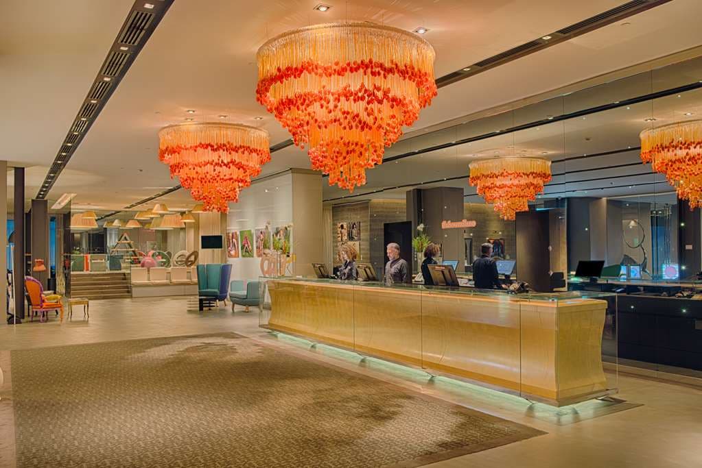 The signature orange 'Tunnel' entrance of nhow Milano featuring undulating walls and warm lighting.