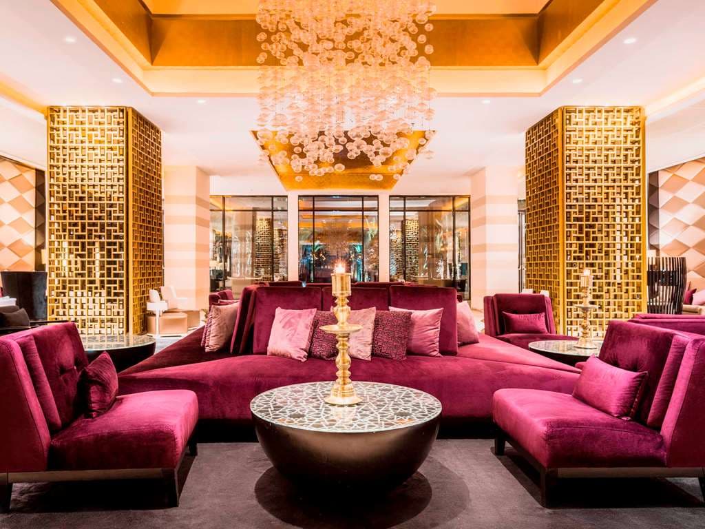 A hexagonal swimming pool at Sofitel Rabat surrounded by tall palm trees and white lounge chairs under the Moroccan sun.