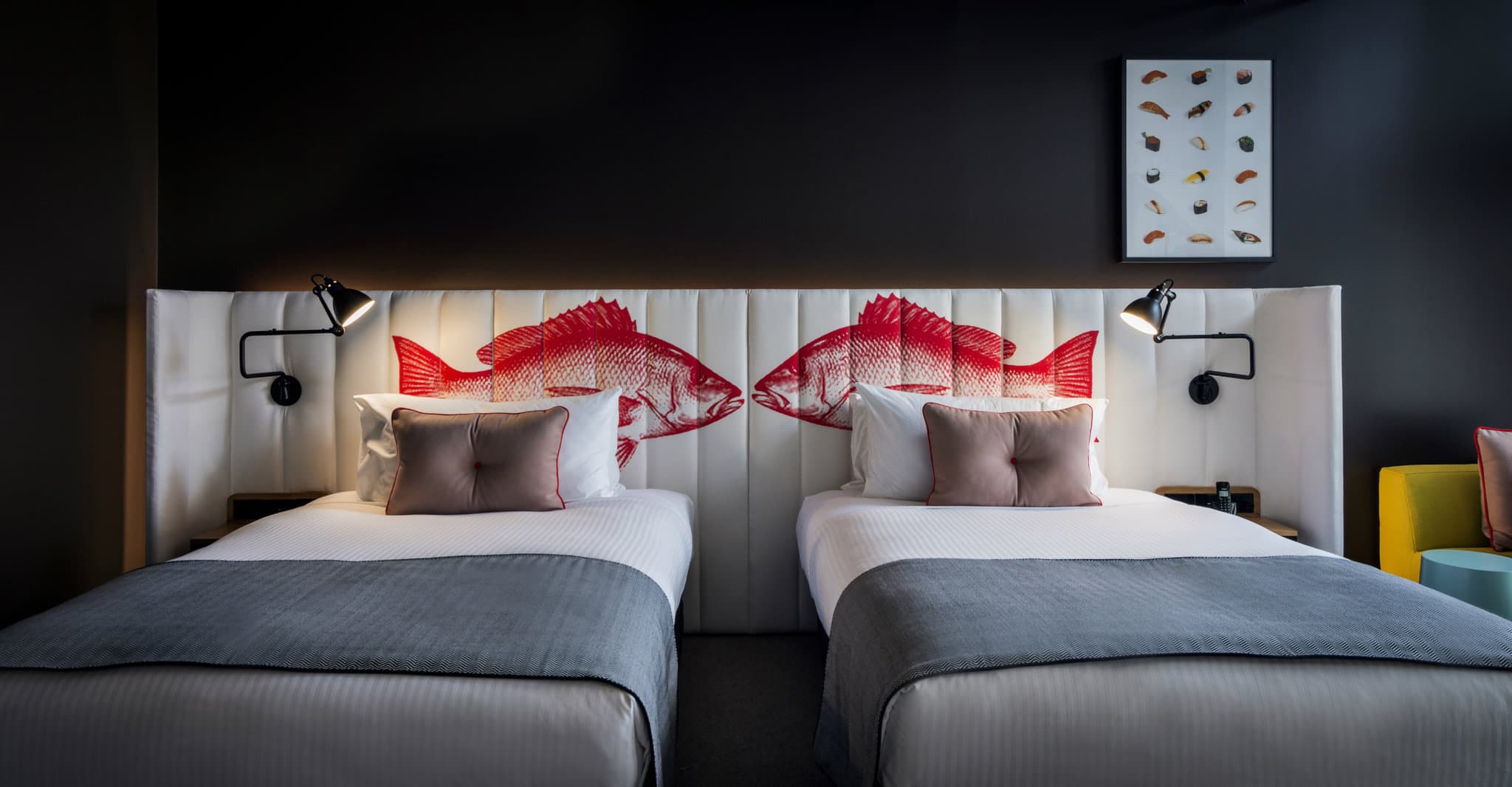 Ovolo Woolloomooloo 飯店內部，展示了歷史悠久的木質工業樑與霓虹燈光和現代天鵝絨家具的對比。