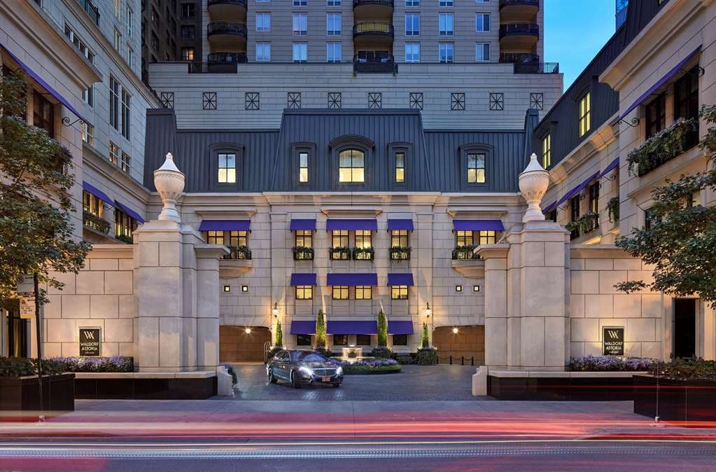 A luxurious Waldorf Astoria Chicago suite featuring a lit gas fireplace, plush seating, and a private terrace overlooking the Gold Coast skyline.
