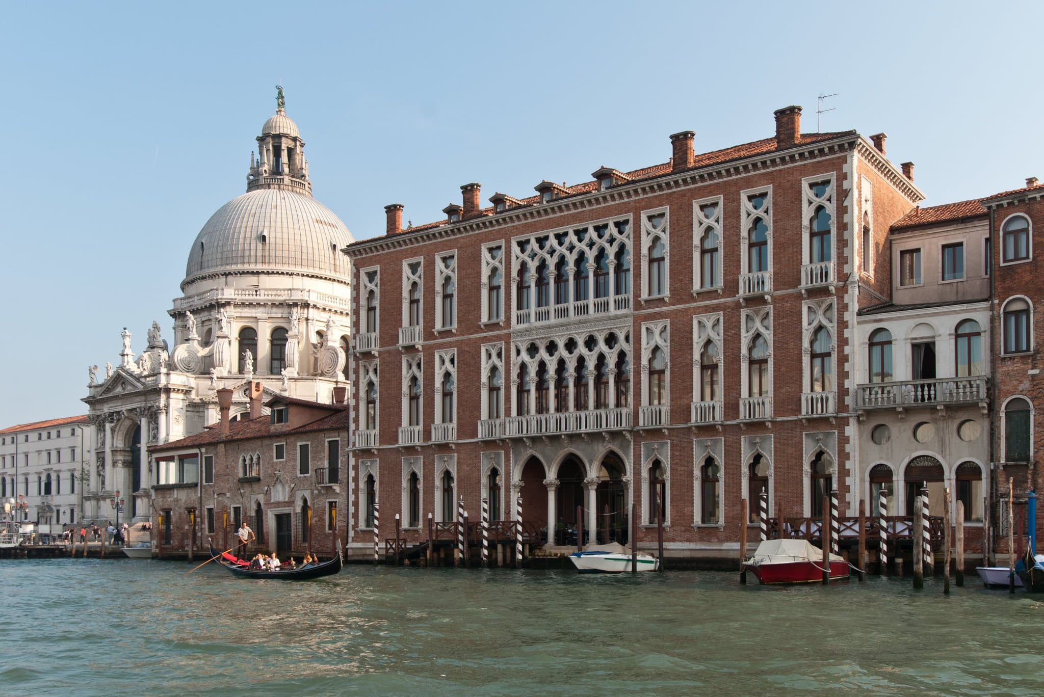 View from Antinoo’s Lounge terrace at Sina Centurion Palace, featuring white tablecloth dining setups directly overlooking the Grand Canal and the Santa Maria della Salute dome.