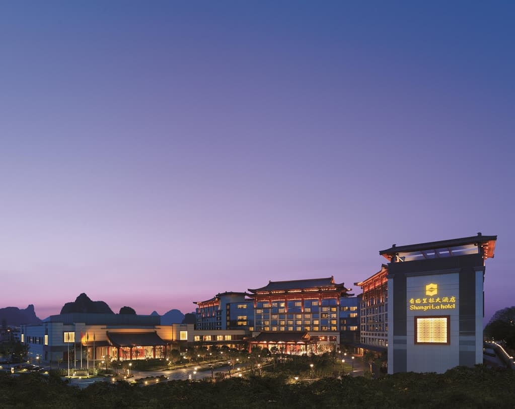 View from Shangri-La Guilin Lobby Lounge featuring floor-to-ceiling windows framing the Li River and distant karst mountains.