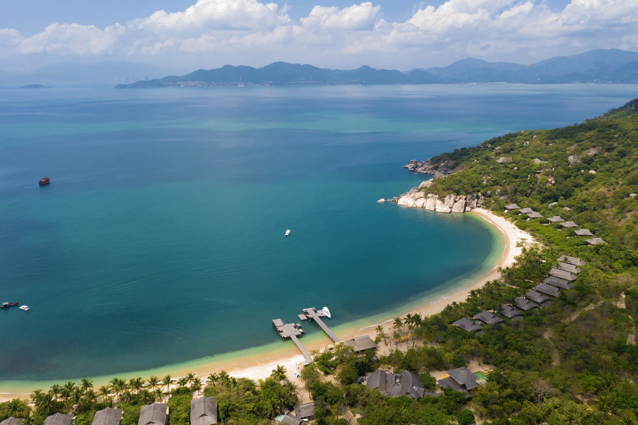 A guest relaxing in a private infinity pool at the Rock Pool Villa, Six Senses Ninh Van Bay, overlooking granite boulders and the turquoise sea.