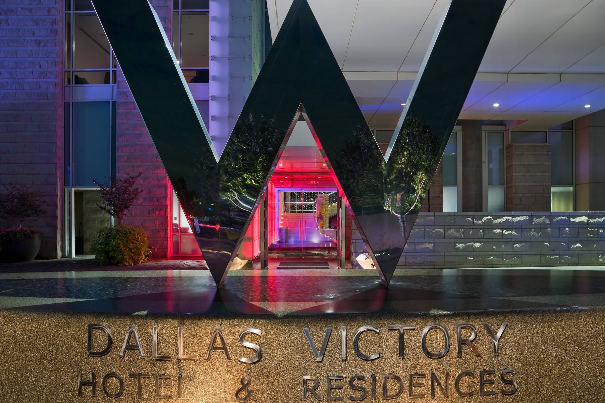 View of the W Dallas Victory WET Deck infinity pool overlooking the Dallas skyline at dusk.
