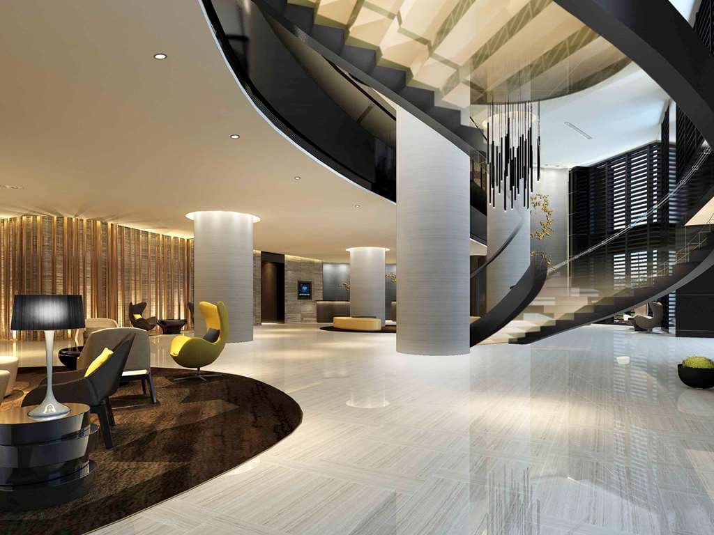 Grand Mercure Dongguan Humen lobby featuring a dramatic illuminated curved staircase and reflective dark ceiling.