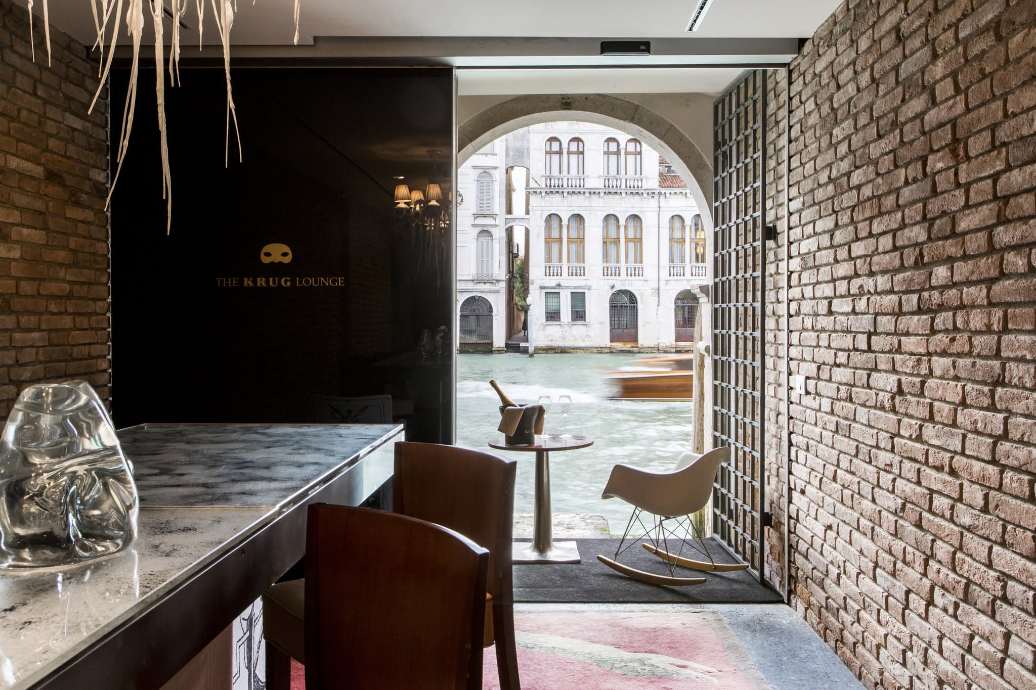 A moody, Philippe Starck-designed lounge at Palazzina Grassi with low lighting, velvet seating, and mirrored accents.