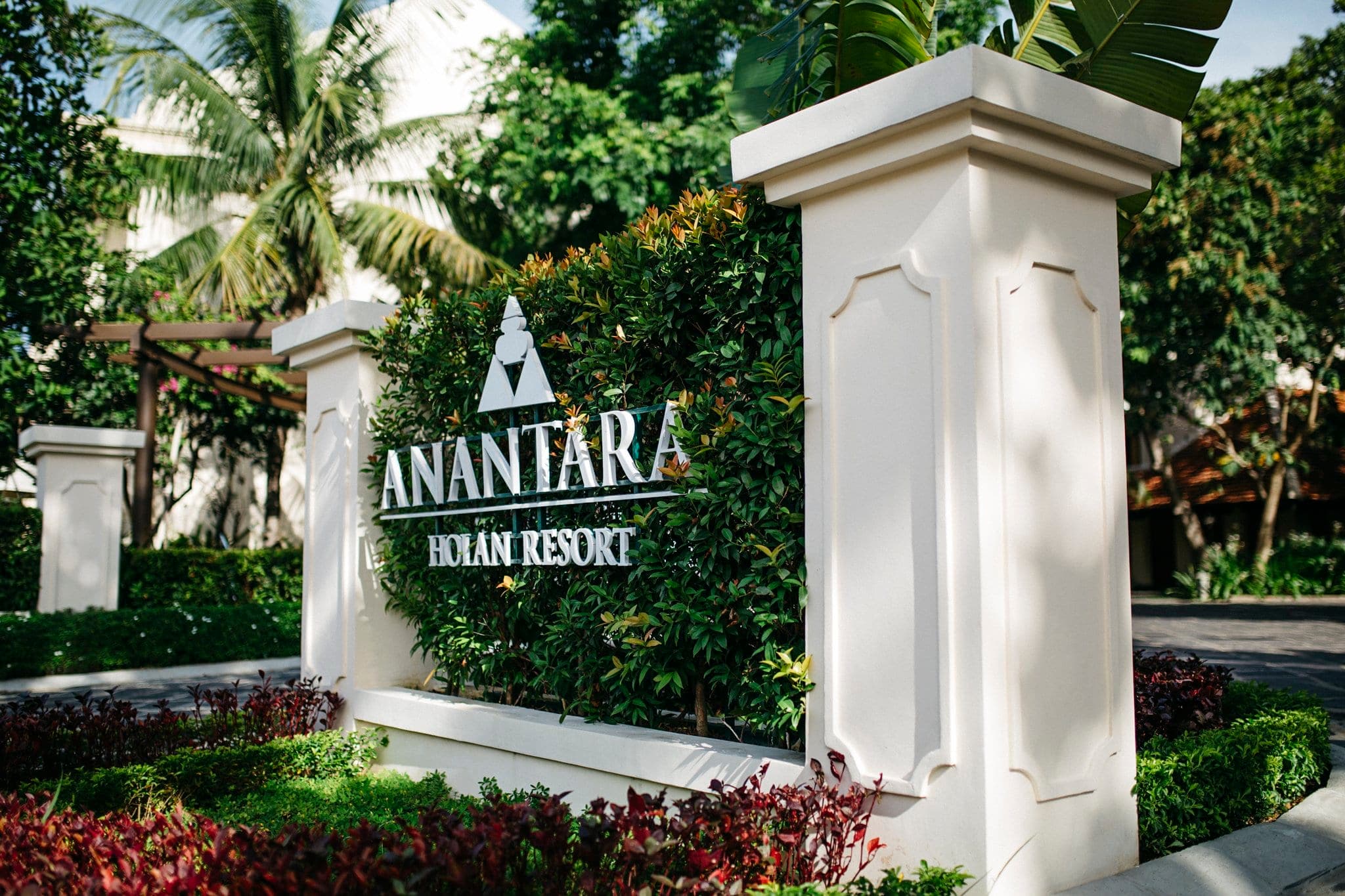 Anantara Hoi An Resort riverside colonial facade with lantern-lit sampans on the Thu Bon River.