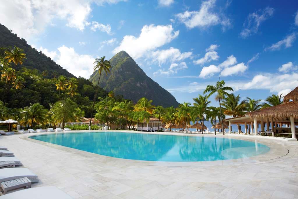 White colonial-style villas with private plunge pools nestled between the green peaks of the Pitons in Saint Lucia.