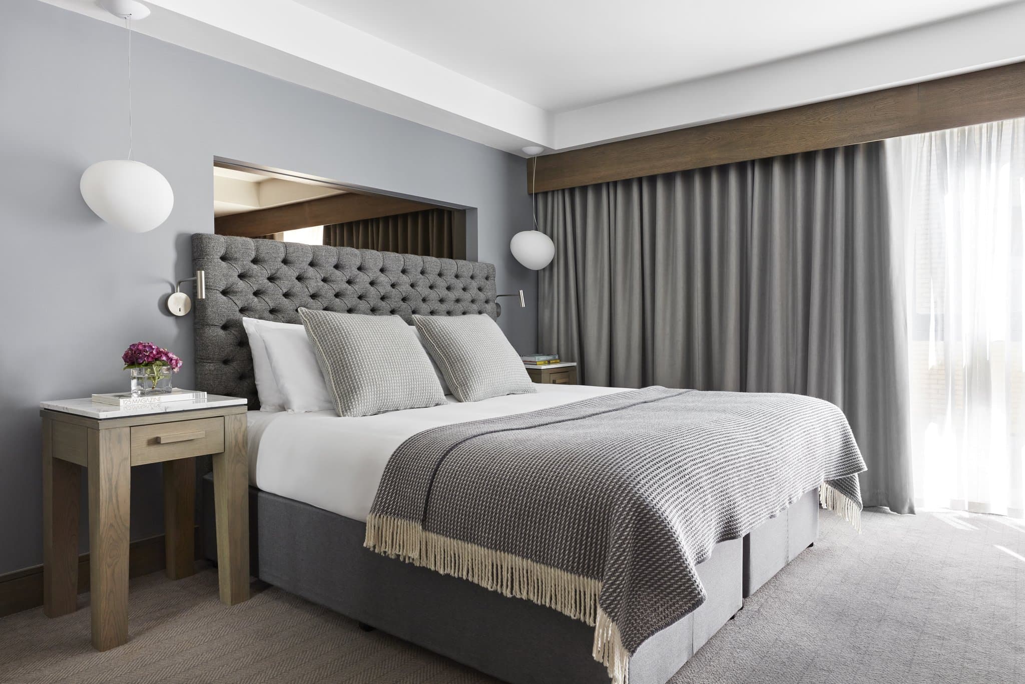 Kimpton Blythswood Square酒店的鍛鐵大廳樓梯，搭配大理石地板和寶石色調的天鵝絨家具。