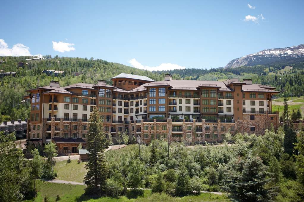 Viceroy Snowmass outdoor infinity pool terrace with waterfall, overlooking the Assay Hill ski lift.