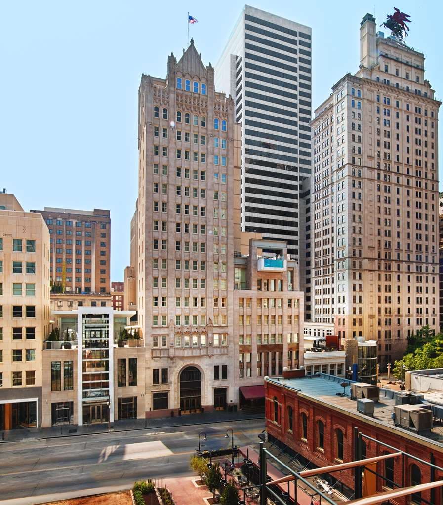 The Joule Dallas cantilevered rooftop pool extending over Main Street with neo-Gothic architecture in background