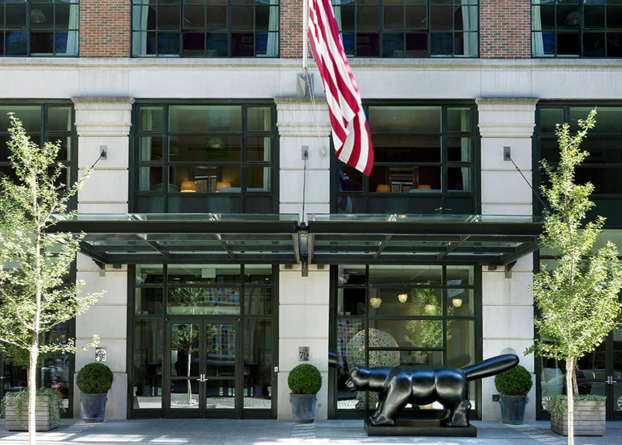 The Crosby Street Hotel's vibrant lobby featuring the signature bronze Botero cat sculpture and colorful contemporary art.