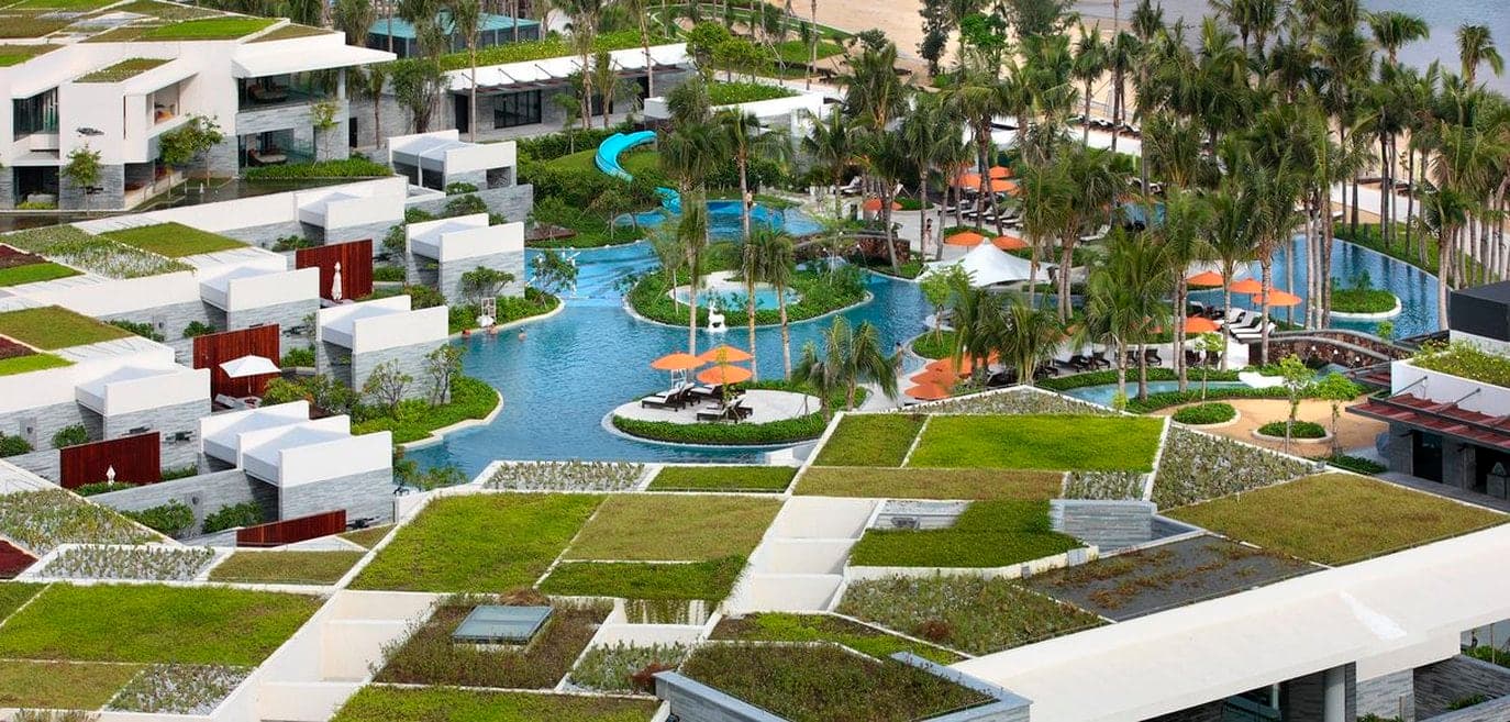 Aerial view of InterContinental Sanya Resort showing WOHA's geometric green roofs and water courtyards.