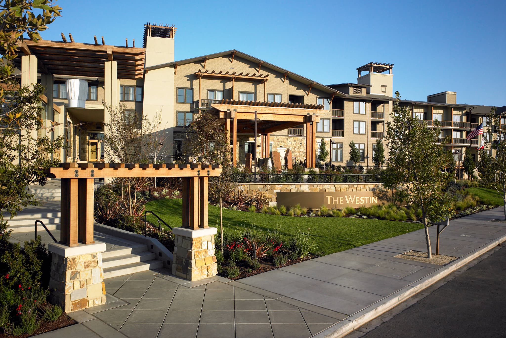 The Westin Verasa Napa saltwater pool surrounded by cabanas and lush greenery during the day.