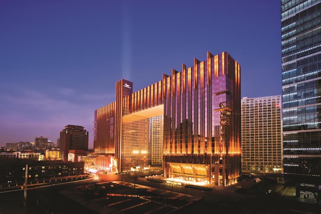 The iconic rose-gold glass exterior of Fairmont Beijing featuring the connecting Sky Bridge architecture.