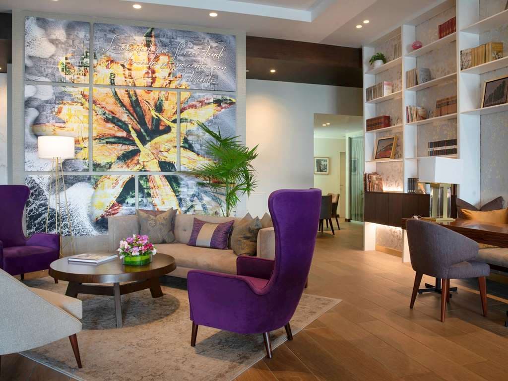Manto Hotel Lima patio featuring colonial floor tiles, vertical garden walls, and cozy velvet seating at Saya Terraza.