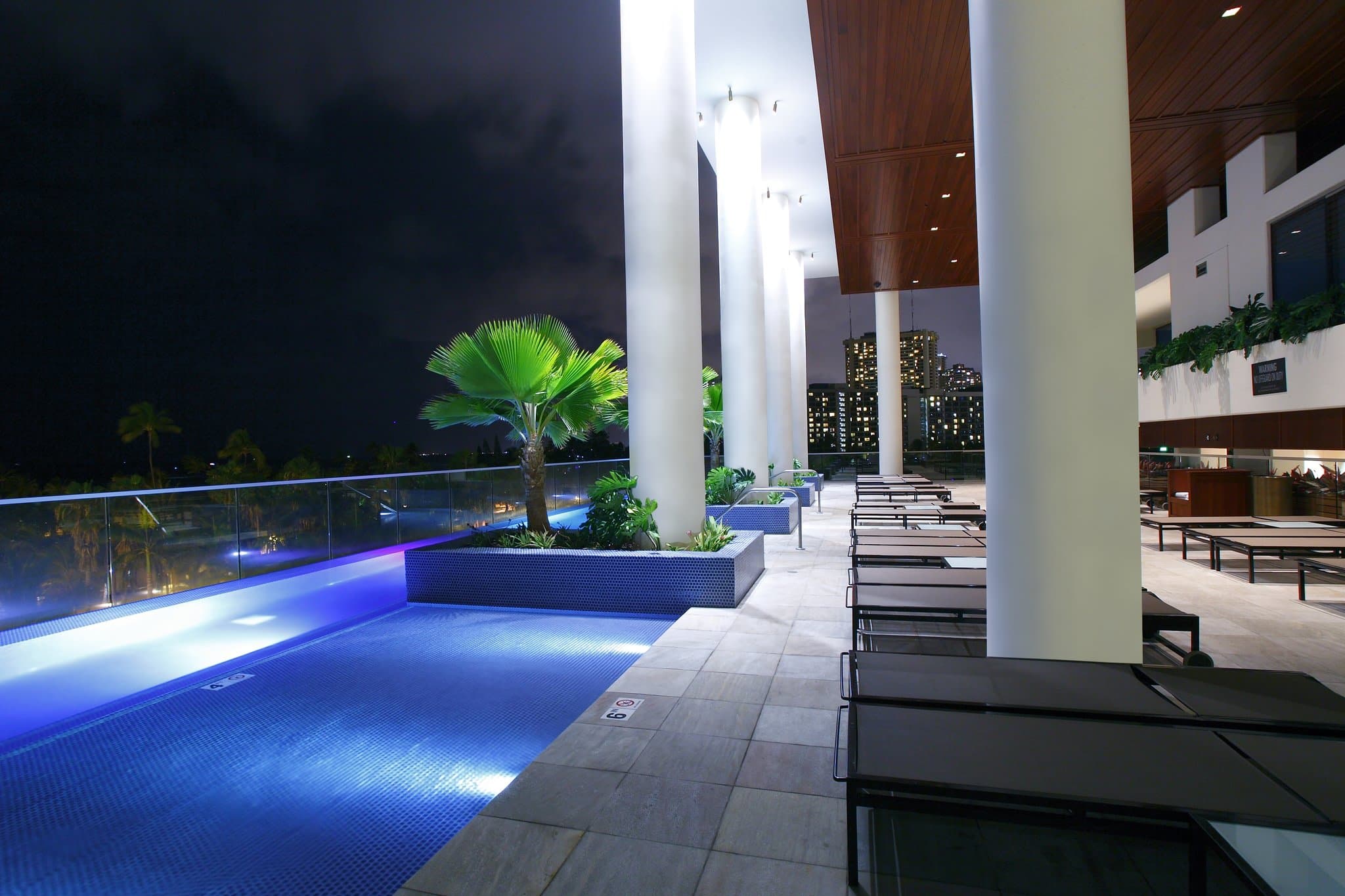 View from Ka La'i Waikiki Beach infinity pool overlooking the Pacific Ocean and Fort DeRussy Park greenery.