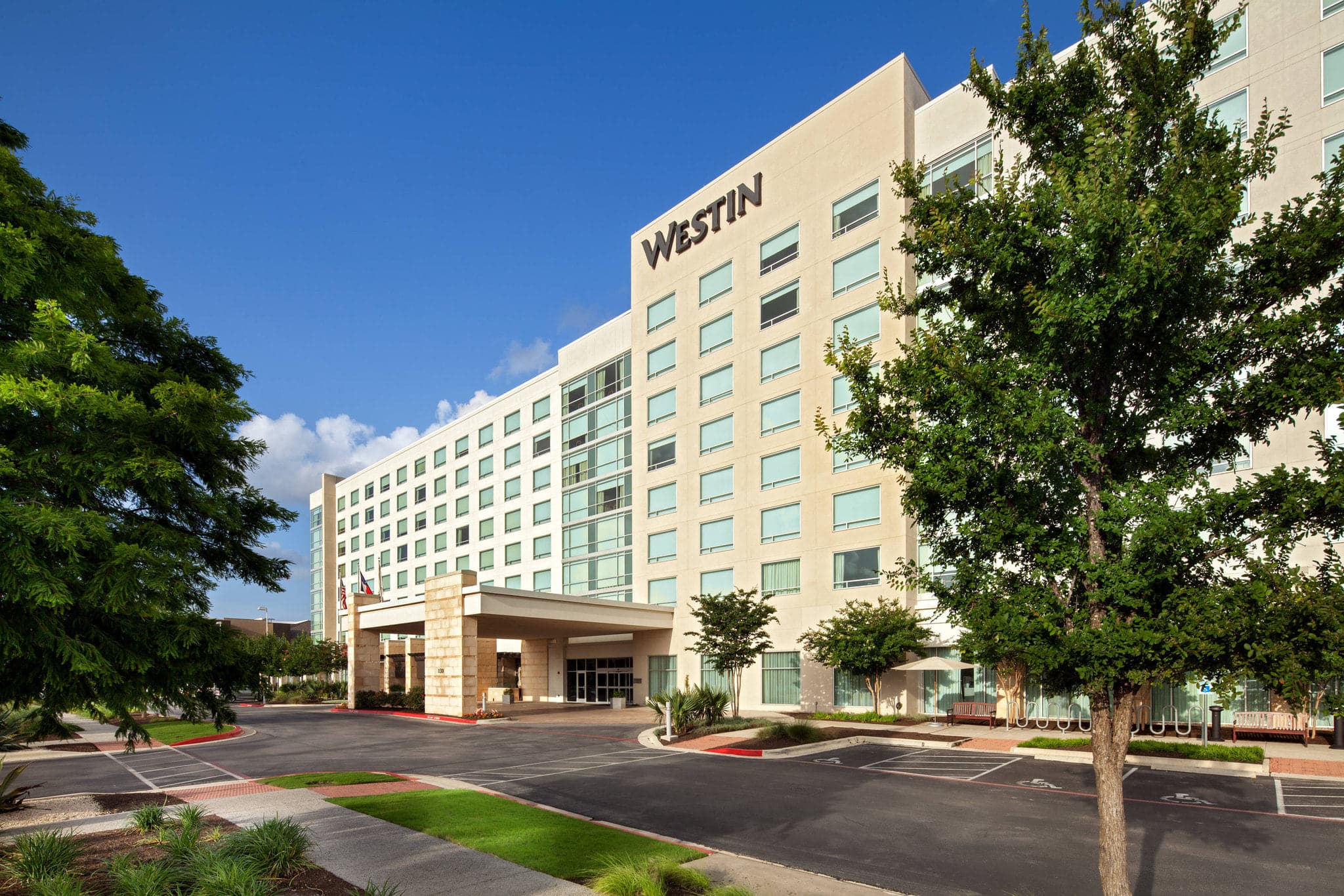 The Westin Austin pool deck at twilight with illuminated Urban Lounge and modern sun loungers.