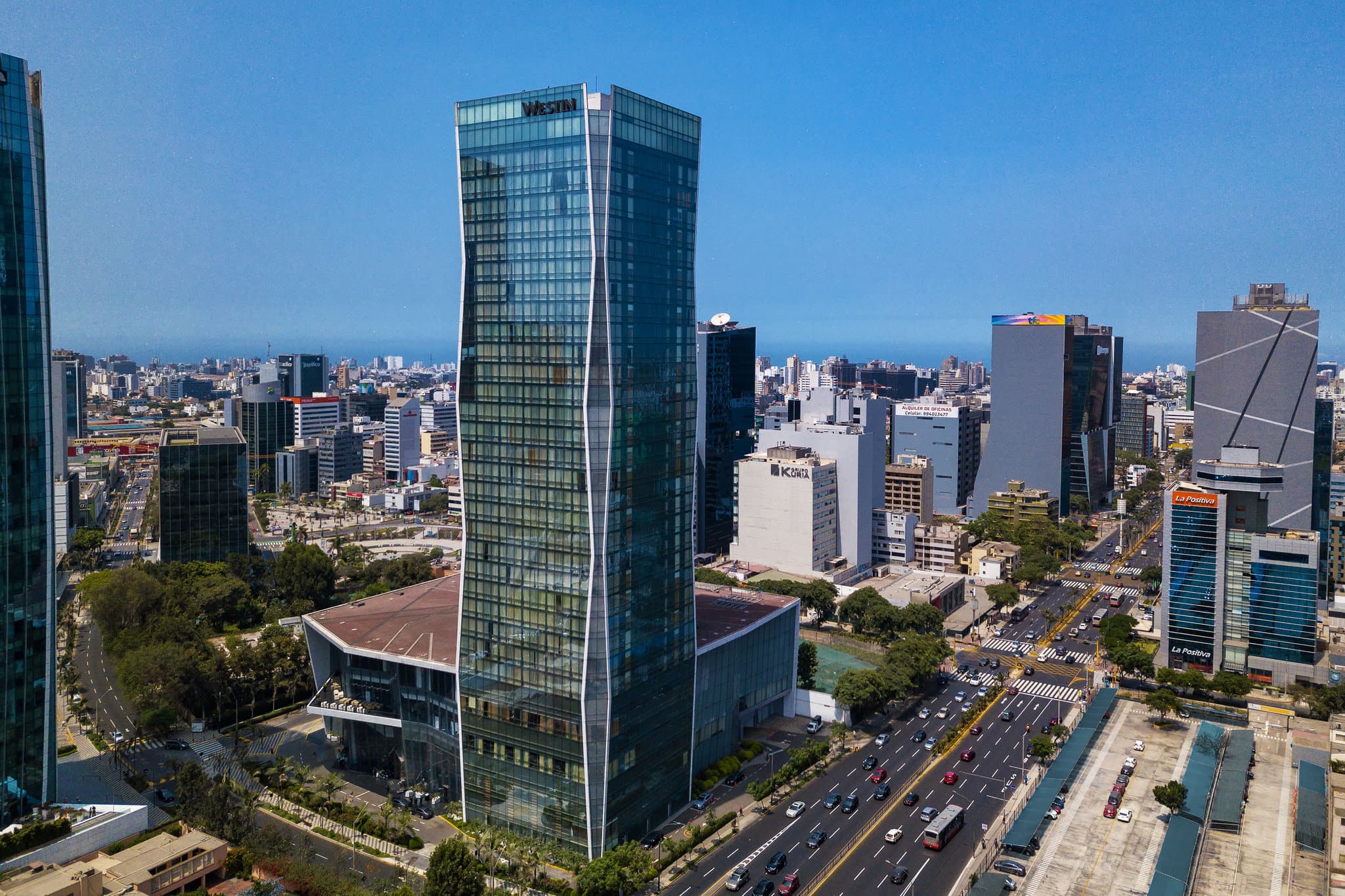 The illuminated glass facade of The Westin Lima towering over the San Isidro financial district at twilight.