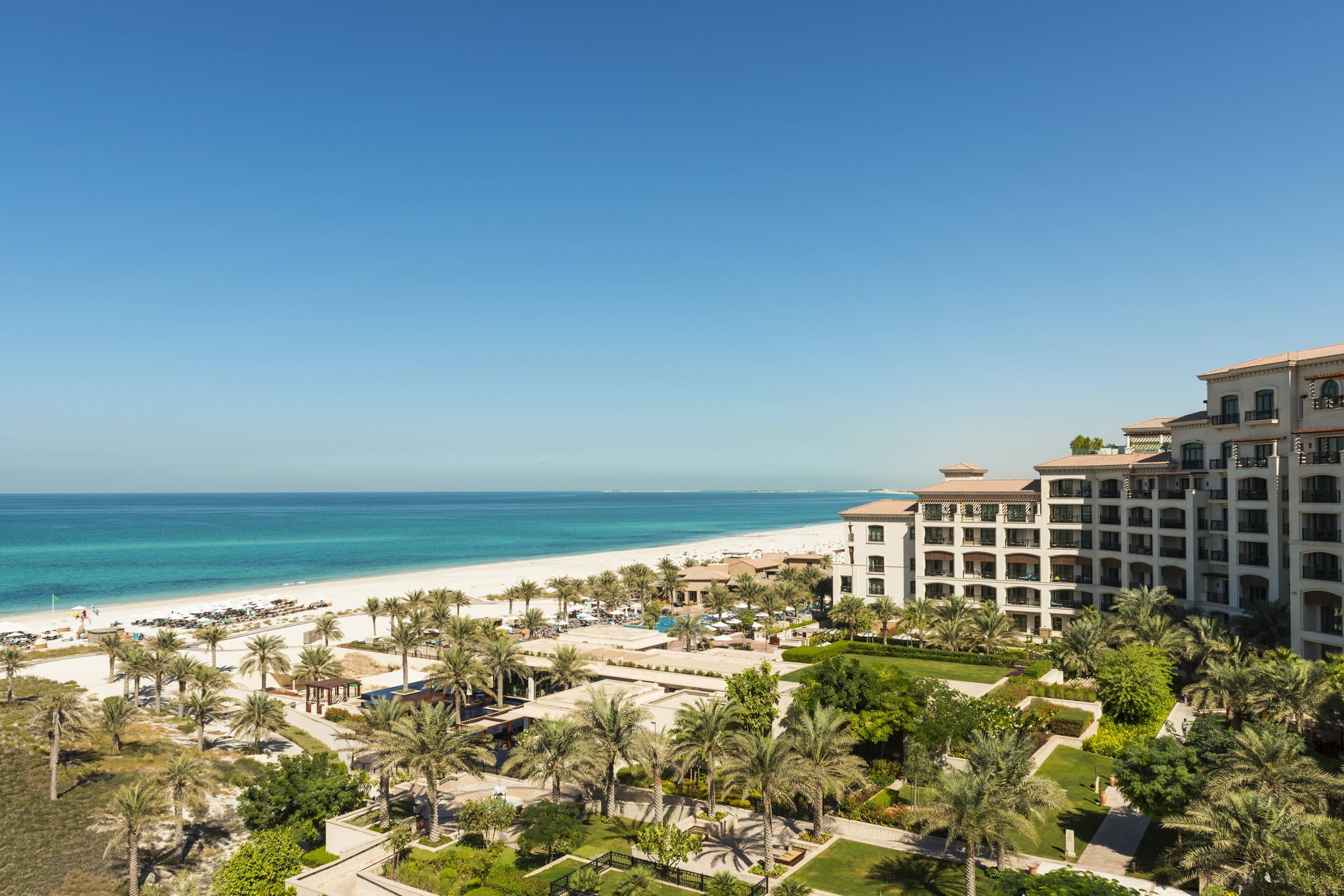 Sunset view of Sontaya's floating pavilions at The St. Regis Saadiyat Island Resort with reflection in the water.