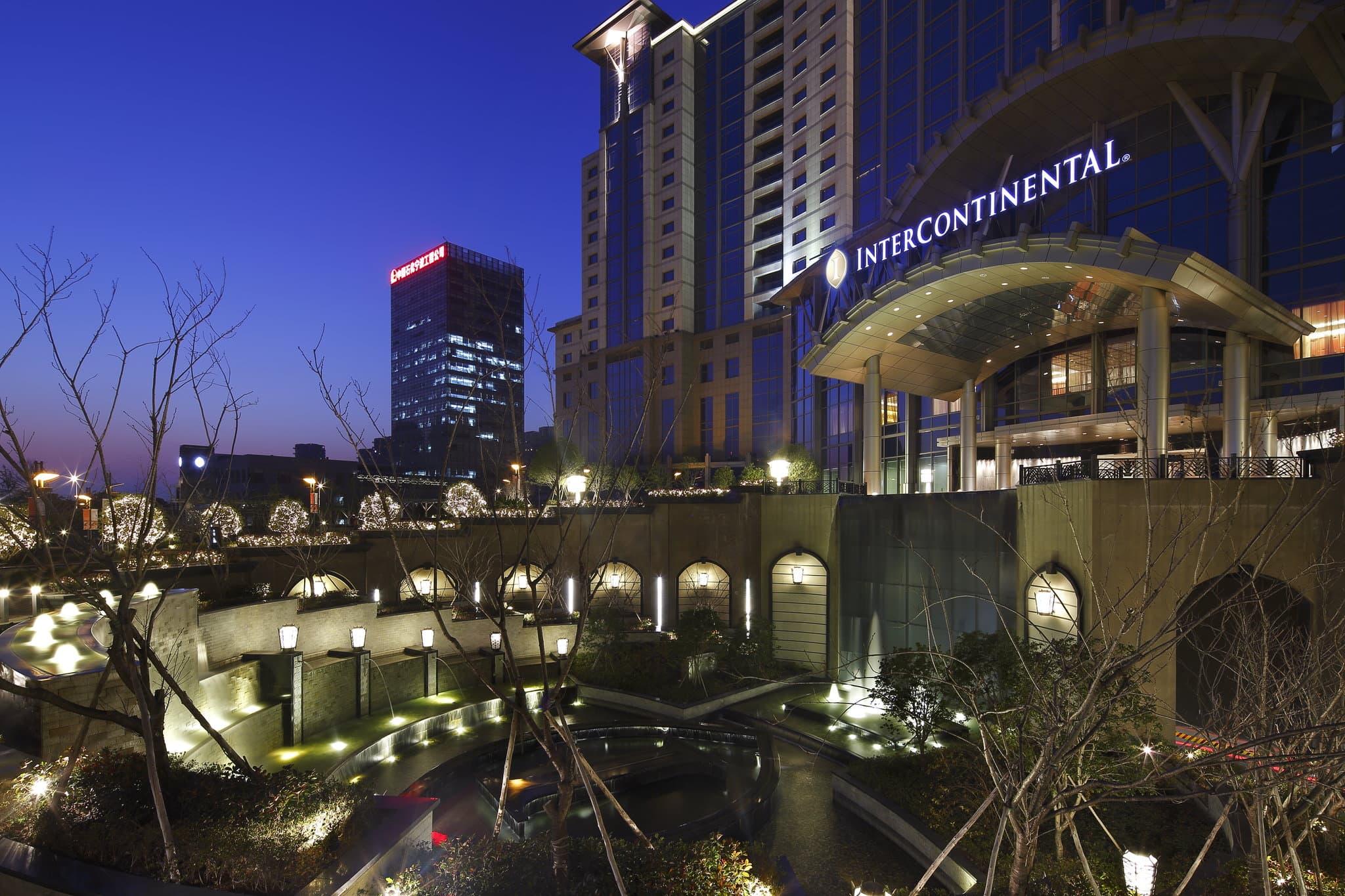 A serene view of The Azure Ningbo's European-style manicured gardens contrasting with the modern high-rise skyline of the National High-tech Zone.