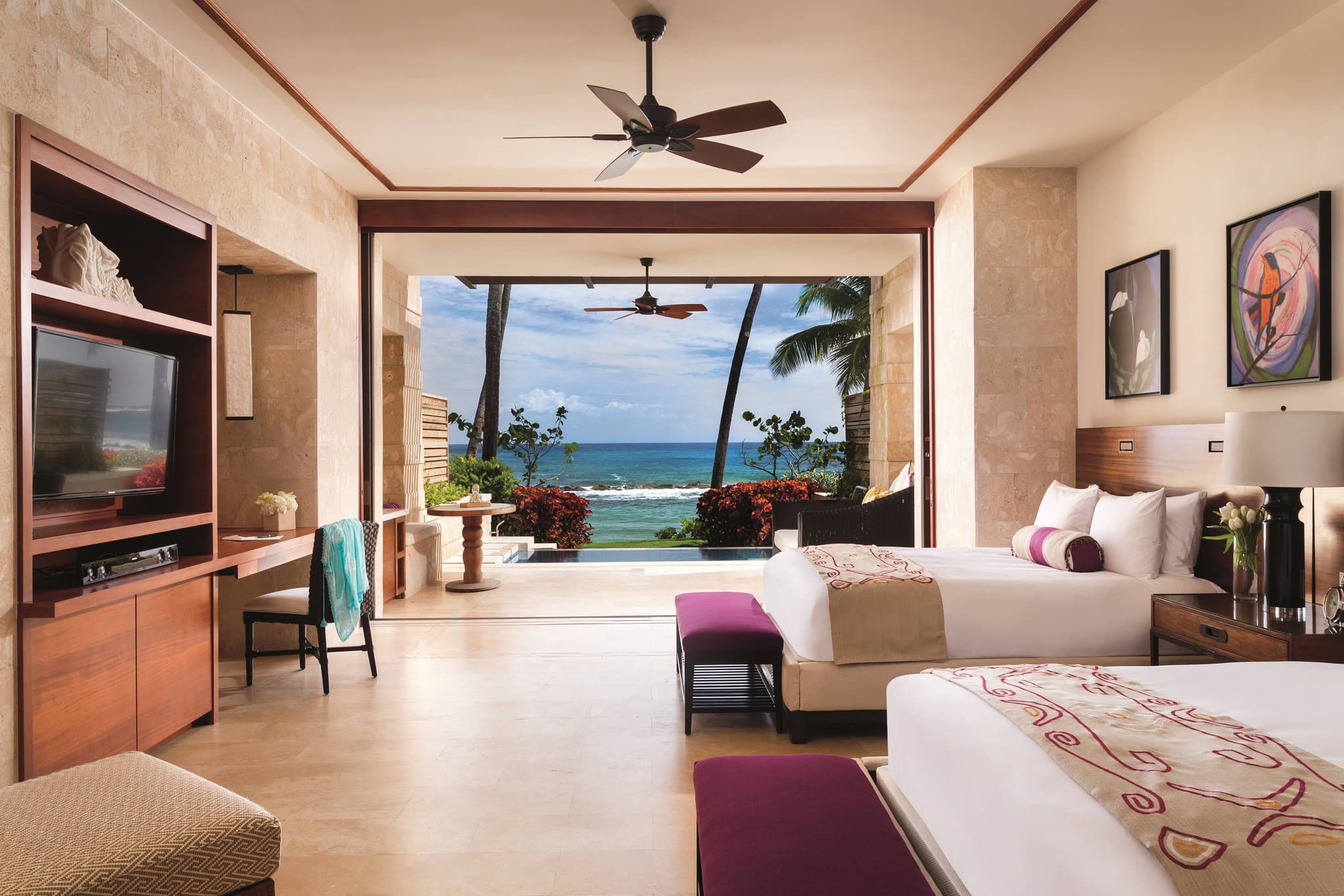 A lush, open-air suite at Dorado Beach with a private plunge pool overlooking the ocean, framed by palm trees.