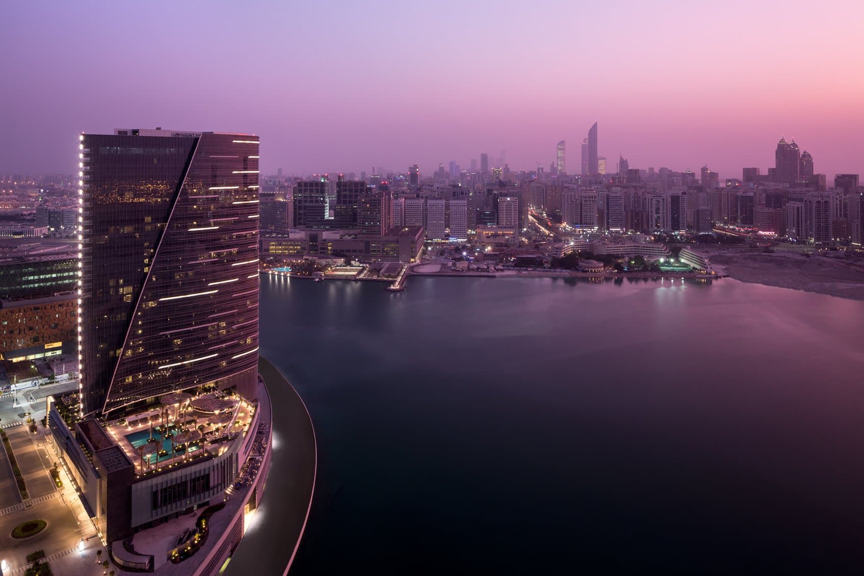 The Glo lounge at Rosewood Abu Dhabi featuring giant illuminated 'Globrella' sculptures against the night skyline.