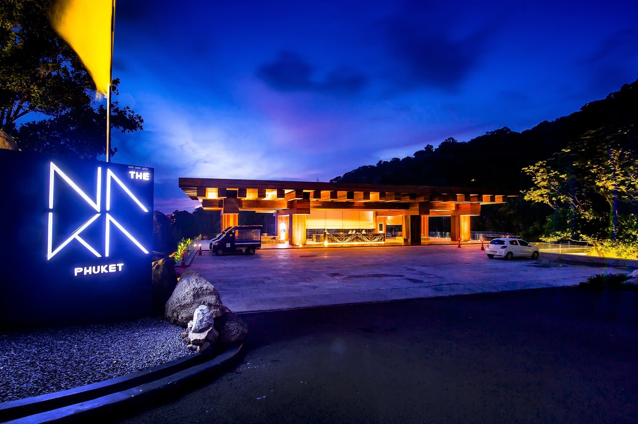 A steel and glass cantilevered villa at The Naka Phuket projecting out from a green jungle hillside over the ocean.
