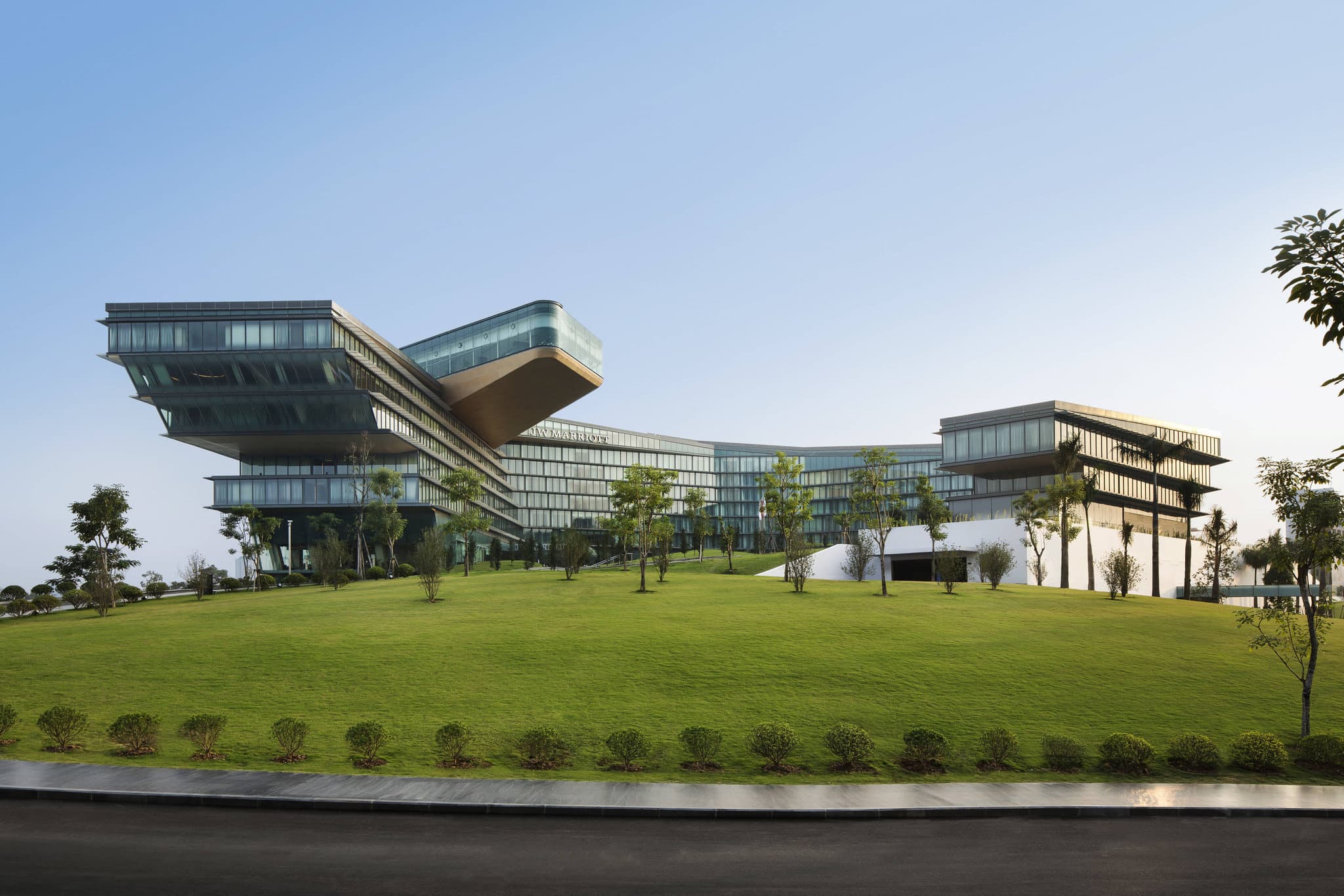 The futuristic, cantilevered indoor pool at JW Marriott Hanoi extending out over the city skyline at twilight.